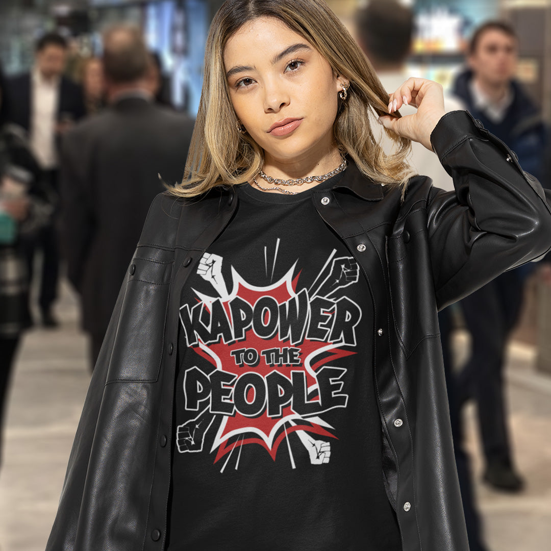 Woman in shopping centre. This anti government t shirt packs a punch with this humorous play on the slogan 'Power to the people', with a comic book twist. Support true democracy with this funny political message. Made from 100% organic ring-spun cotton, this unisex non conformist t shirt is a total must-have. It's high-quality, super comfy, and best of all, eco-friendly