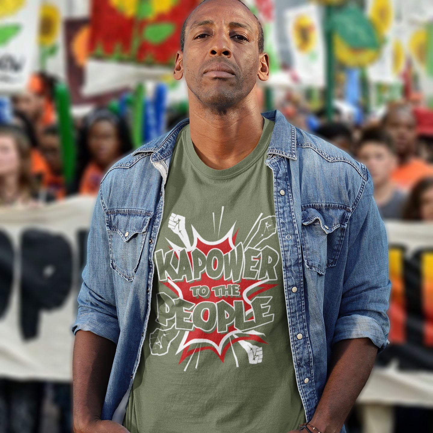 Man wearing a khaki t-shirt with 'Kapower to the People' text in a colourful setting. This anti government t shirt packs a punch with this humorous play on the slogan 'Power to the people', with a comic book twist. Support true democracy with this funny political message. Made from 100% organic ring-spun cotton, this unisex non conformist t shirt is a total must-have. It's high-quality, super comfy, and best of all, eco-friendly.