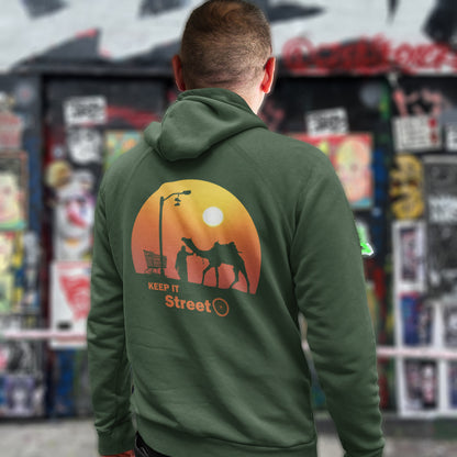 Person wearing a bottle green hoodie with a graphic design on the back, standing in front of a colourful store display. This street art inspired hoodie design represents inner city street life as a culture of it's own.  Wherever you are in the world, may the street be with you. Comfortable and practical. It's extra soft and has a convenient front pouch pocket. Made from organic cotton and recycled polyester, this street art hoodie is a great eco-friendly choice.