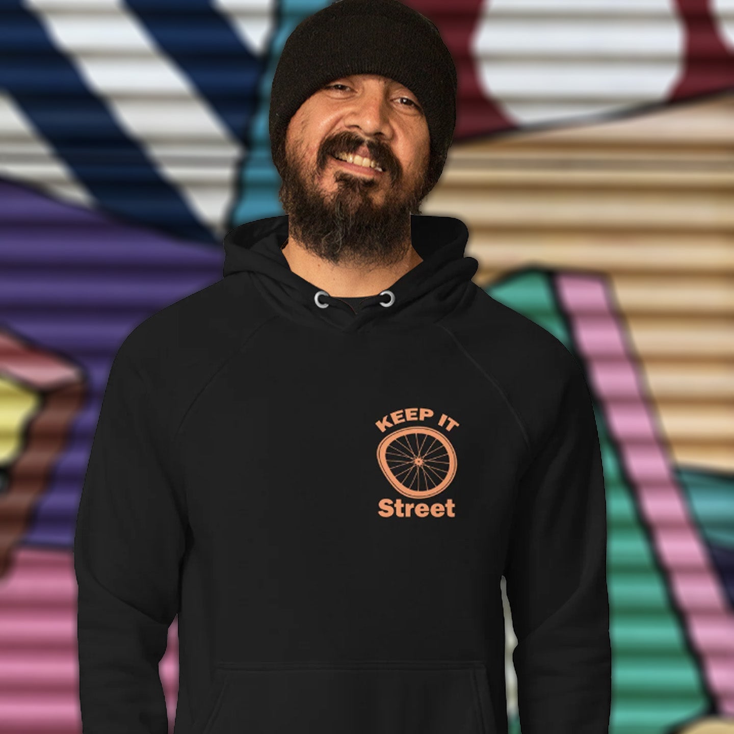Man wearing a black hoodie with 'Keep It Street' logo against a colorful abstract background This street art inspired hoodie design represents inner city street life as a culture of it's own.  Wherever you are in the world, may the street be with you. Comfortable and practical. It's extra soft and has a convenient front pouch pocket. Made from organic cotton and recycled polyester, this street art hoodie is a great eco-friendly choice.