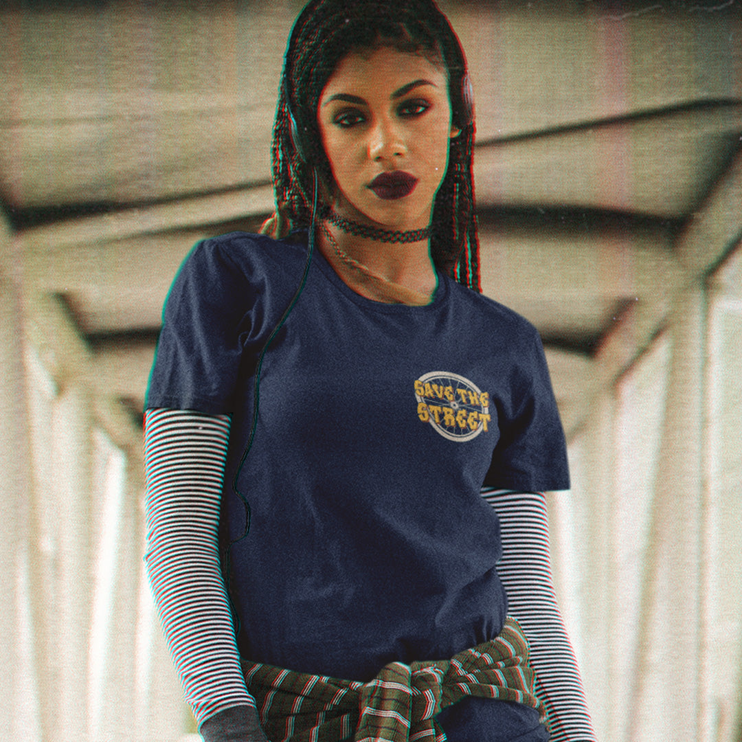 Woman wearing a blue t-shirt with text, standing indoors. This street art t shirt stencil represents inner city street life as a culture of it's own. There is a ground level reality mixed with trustworthy honestly at street level in towns and cities across the planet. Wherever you are in the world, may the street be with you. Made from 100% organic ring-spun cotton, this urban art t shirt is unisex, high-quality, super comfy, and best of all, eco-friendly.