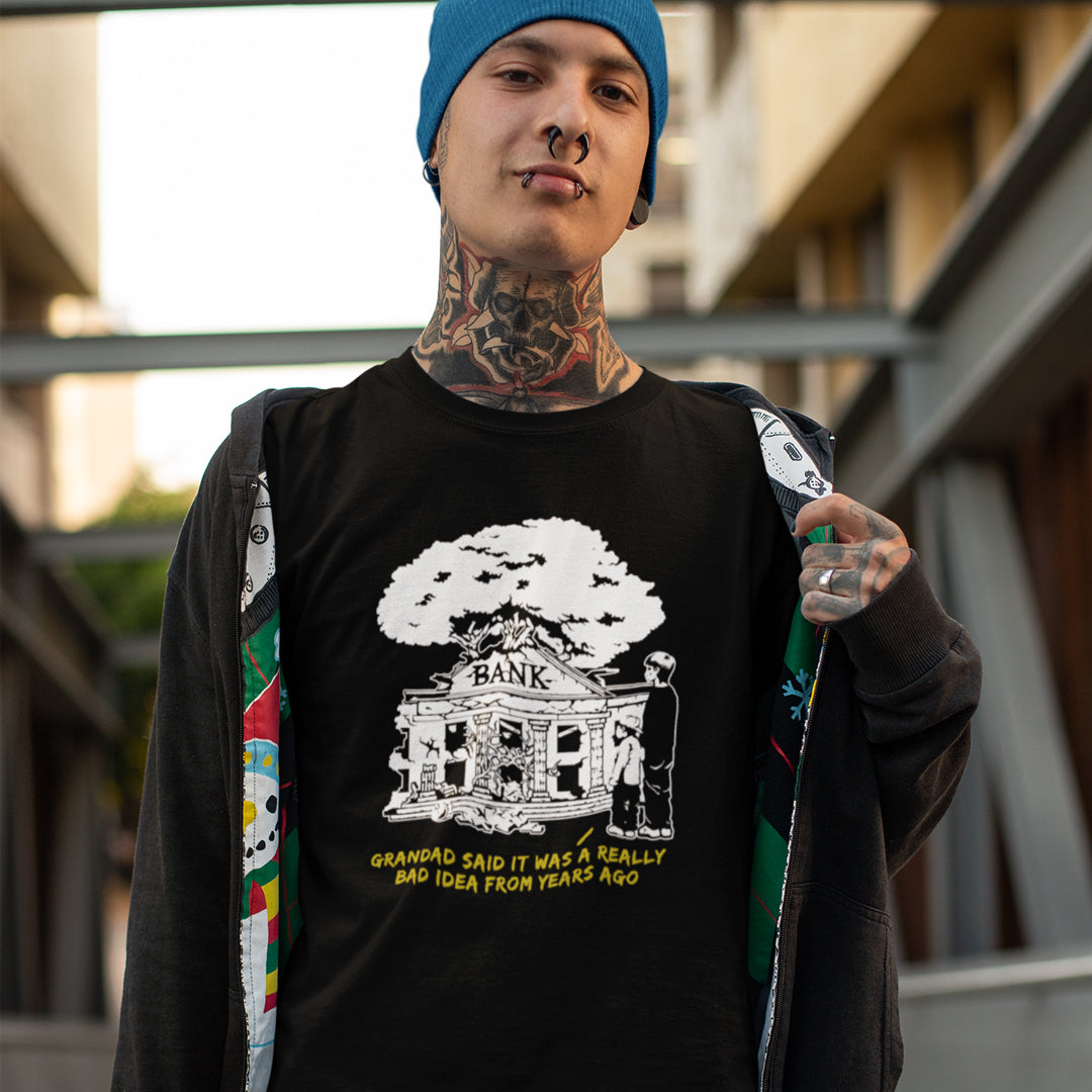 Tattooed man wearing a black t-shirt  with a design of a run down Bank.