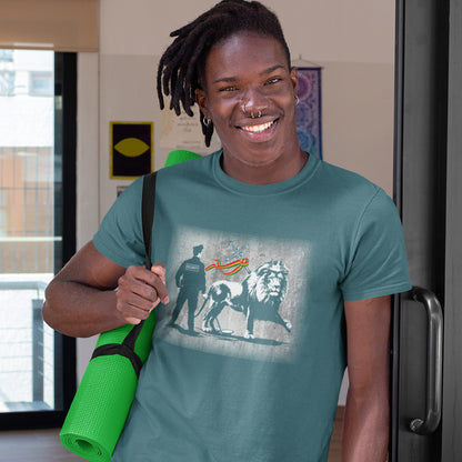 A man with dreadlocks and piercings holding a yoga mat and wearing a stargazer blue short sleeved crew neck t-shirt with a graffiti stencil design of a security guard checking the underside of the Lion of Judah for explosives.
