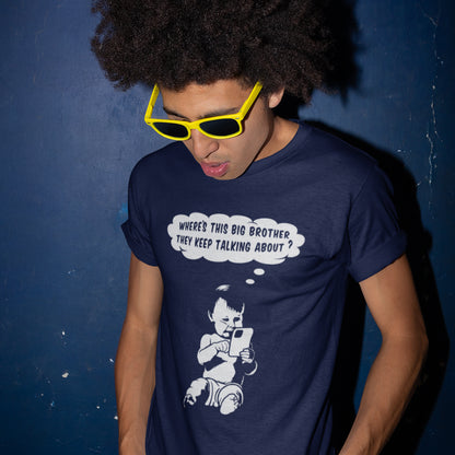 Person wearing a French navy blue t-shirt with a graphic and text, standing against a dark blue wall. A witty conspiracy theory t-shirt questioning the existence of a controlling 'Big Brother' watching over us. This unique design in stencil art illustrates the sweet mind of a child and a lesson in how to take things literally. Big Brother is everywhere and nowhere. Made from 100% organic ring-spun cotton, this Banksy style conspiracy theory t-shirt is unisex, high-quality, super comfy, and best of all, eco-