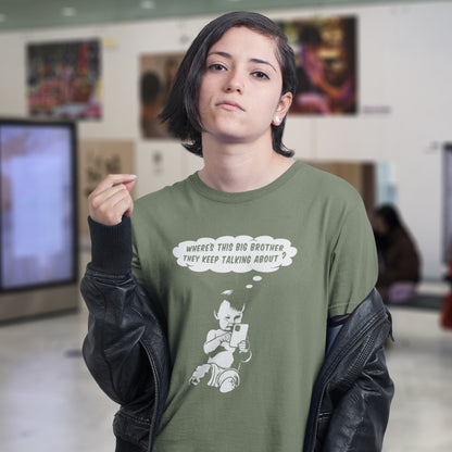 Person wearing a khaki t-shirt with a graphic design and text in an indoor setting. A funny conspiracy theory t shirt questioning the existence of a controlling 'Big Brother' watching over us. This unique design in stencil art illustrates the sweet mind of a child and a lesson in how to take things literally. Big Brother is everywhere and nowhere. Made from 100% organic ring-spun cotton, this stencil graffiti t shirt is unisex, high-quality, super comfy, and best of all, eco-friendly.