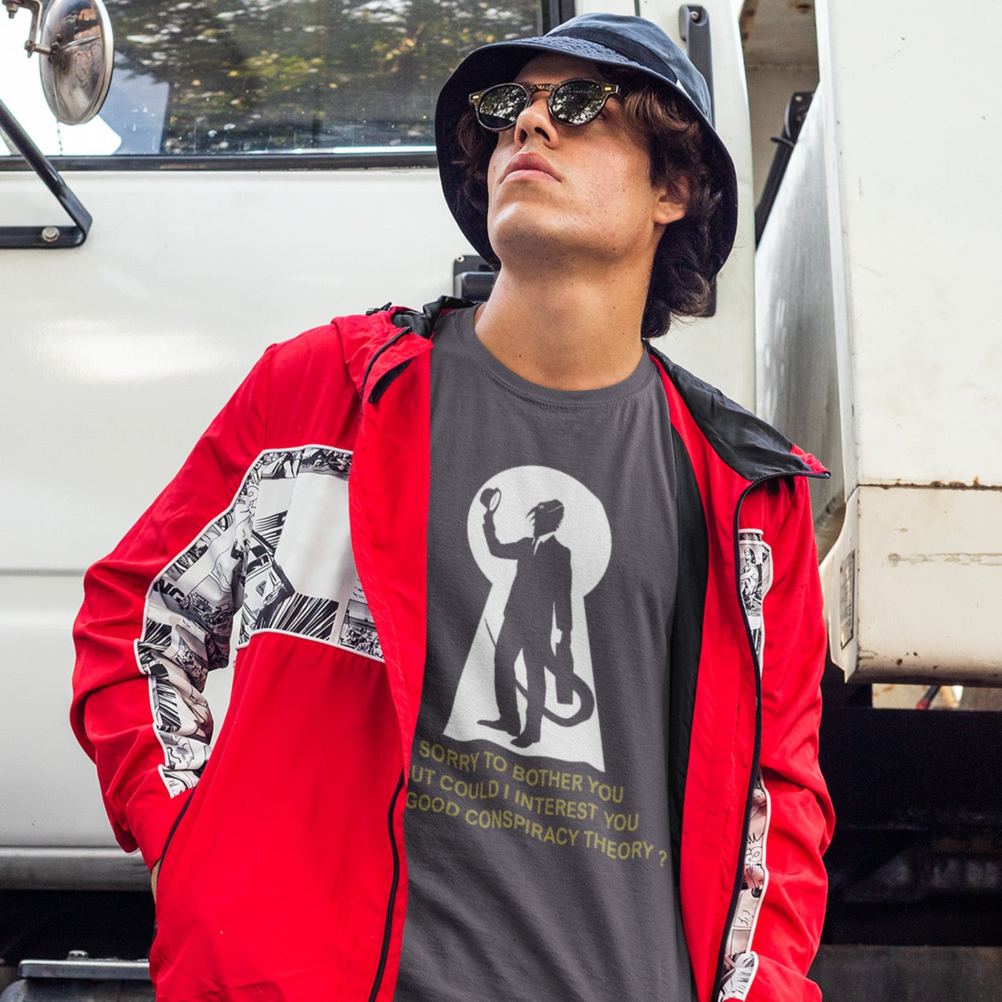 Person wearing a red jacket and anthracite t-shirt with a graphic design, standing in front of a white van. A funny conspiracy theory t-shirt. Just an ordinary, everyday, door-to-door conspiracy theory salesman. Made from 100% organic ring-spun cotton, this reptilian alien t-shirt is unisex, high-quality, super comfy, and best of all, eco-friendly.