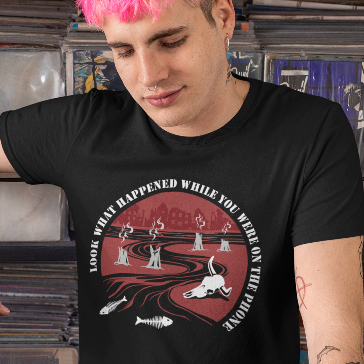 Person wearing a black t-shirt with a graphic design and text. An anti mobile phone abuse theme mixed with a save the earth t shirt. This design is a harsh view of what's happening to the planet while people are distracted by their phones. Made from 100% organic ring-spun cotton, this save the planet t shirt is unisex, high quality, super comfy, and best of all, eco-friendly.
