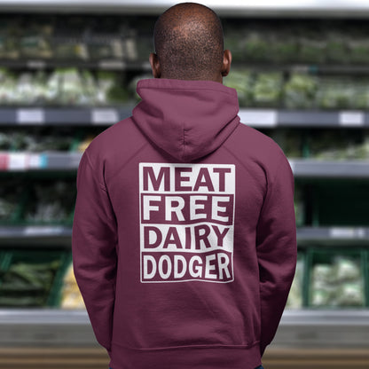Person wearing a burgundy hoodie with 'MEAT FREE DAIRY DODGER' text in a grocery store. This vegan hoodie promotes a witty alternative to the 'non-dairy' label. Never mind 'plant based' as a new label for vegan . This is straight off the streets of East London. Comfortable and practical. It's extra soft and has a convenient front pouch pocket. Made from organic cotton and recycled polyester, this vegan hoodie is a great eco-friendly choice.