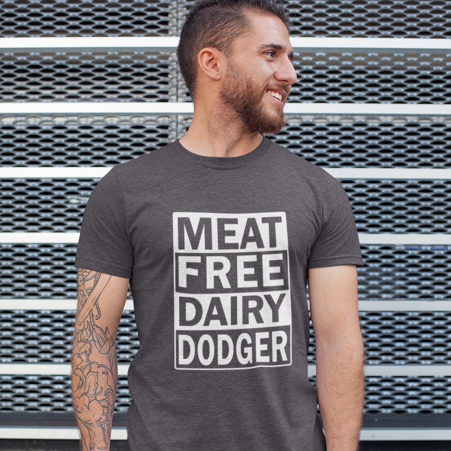 Man wearing a t-shirt with 'MEAT FREE DAIRY DODGER' text against a metal background. A vegan meat free t shirt promoting a witty alternative to the 'vegan' label. Never mind 'plant based' as a new label for vegan . This is straight off the streets of East London. Made from 100% organic ring-spun cotton, this vegan dairy free t shirt is unisex, high-quality, super comfy, and best of all, eco-friendly.