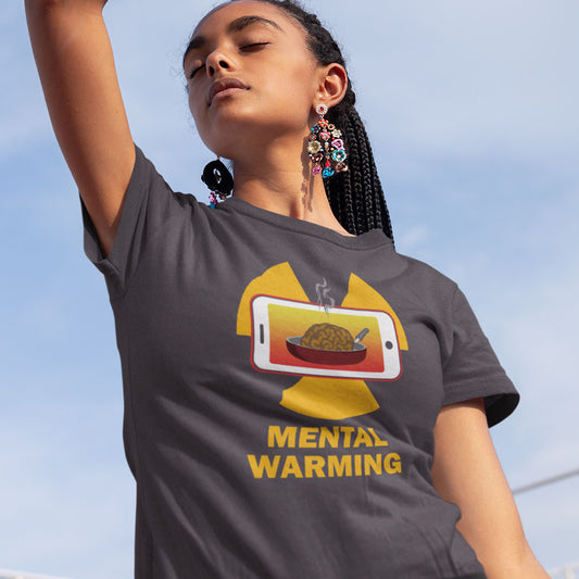 A woman wearing a dark gray graphic t-shirt with a yellow and red 'Mental Warming' design, photographed from a low angle against a blue sky.