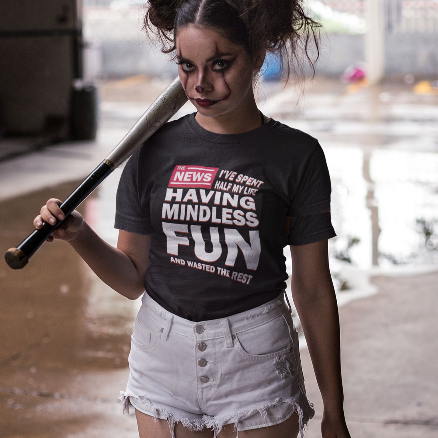 Person wearing a black t-shirt with humorous text and holding a baseball bat in an indoor setting. A witty quotes t shirt with a front page life philosophy. When you look back over your life, How are you going to see it ? Made from 100% organic ring-spun cotton, these clever slogan t shirts are unisex, high-quality, super comfy, and best of all, eco-friendly.