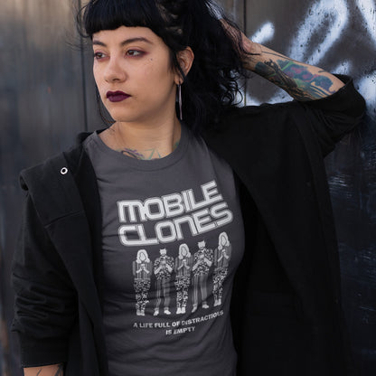 Person wearing a t-shirt with 'Mobile Clones' design against a dark background. Smart phones are taking the imagination out of life. Soon we will all look the same, think the same, and all buy the same un-needed online products, or has that already happened ? Made from 100% organic ring-spun cotton, this anti-consumerism t-shirt is unisex, high-quality, super comfy, and best of all, eco-friendly.