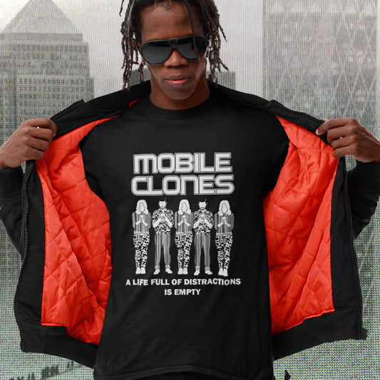 Person wearing a black t-shirt with 'Mobile Clones' design and red jacket, cityscape background. Smart phones are taking the imagination out of life. Soon we will all look the same, think the same, and all buy the same un-needed online products, or has that already happened ? Made from 100% organic ring-spun cotton, this anti-consumerism t-shirt is unisex, high-quality, super comfy, and best of all, eco-friendly.