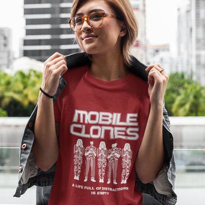 Person wearing a red t-shirt with 'MOBILE CLONES' design outdoors. Smart phones are taking the imagination out of life. Soon we will all look the same, think the same, and all buy the same un-needed online products, or has that already happened ? Made from 100% organic ring-spun cotton, this anti-consumerism t-shirt is unisex, high-quality, super comfy, and best of all, eco-friendly.