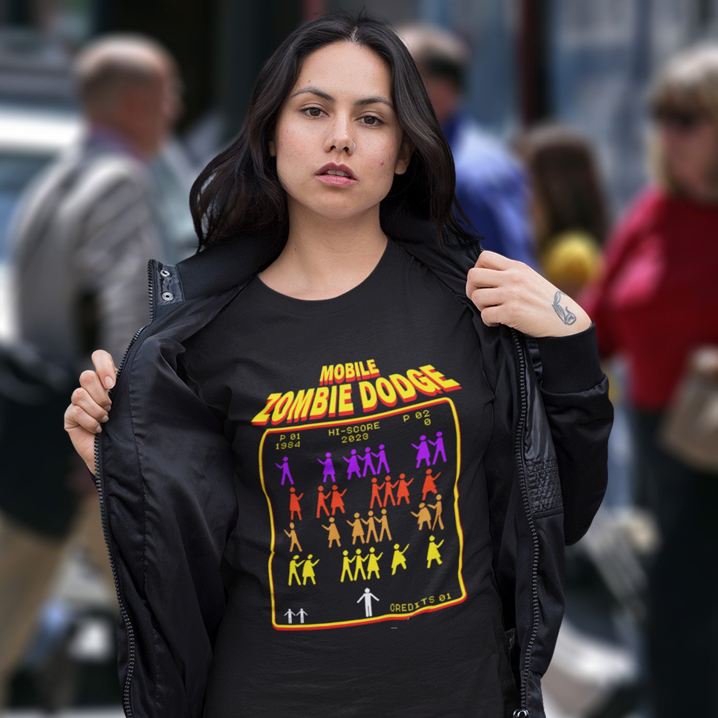 Woman wearing a black t-shirt with 'Mobile Zombie Dodge' graphic design in an urban setting. A satirical gamer t-shirt design for anyone who feels they are in a repetitive 80's video game every time they enter a crowded street scene. Welcome to the age of the mobile phone and lack of social awareness. Made from 100% organic ring-spun cotton, this unisex gamer t-shirt is alternative and original. It's high-quality, super comfy, and best of all—eco-friendly.