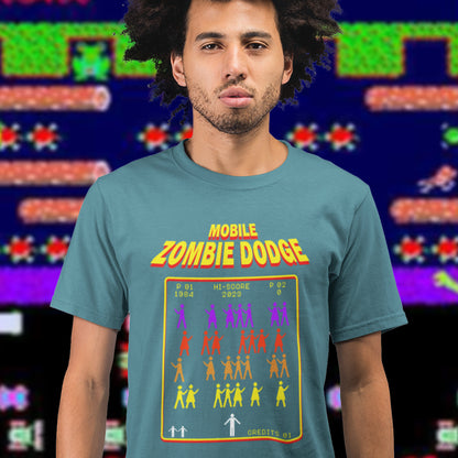 Man wearing a 'Mobile Zombie Dodge' t-shirt with a retro video game design in front of a colourful background. A satirical gamer t-shirt design for anyone who feels they are in a repetitive 80's video game every time they enter a crowded street scene. Welcome to the age of the mobile phone and lack of social awareness. Made from 100% organic ring-spun cotton, this unisex gamer t-shirt is alternative and original. It's high-quality, super comfy, and best of all—eco-friendly.