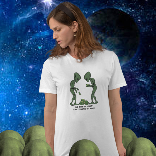 Woman wearing a white t-shirt with alien graphic and text against a space-themed background. This funny anti-capitalism t-shirt is for alien lovers, and depicts the disappointment of a civilisation now overly obsessed with money and greed. Is it any wonder the aliens have given up on us. Made from 100% organic ring-spun cotton, this social awareness/alien t-shirt is unisex, high-quality, super comfy, and best of all, eco-friendly.