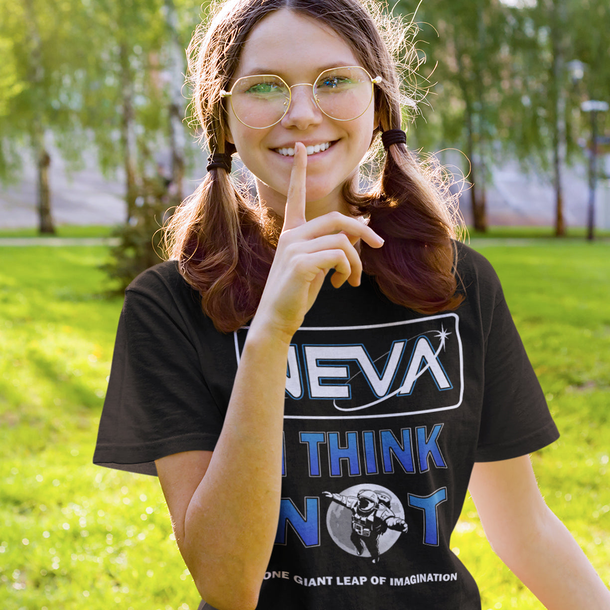 Person wearing a black t-shirt with text and graphics, standing outdoors in a park. A conspiracy theory t-shirt design for all you die hard moon landing sceptics out there. Made from 100% organic ring-spun cotton, this witty conspiracy theory t-shirt is unisex, high-quality, super comfy, and best of all, eco-friendly.