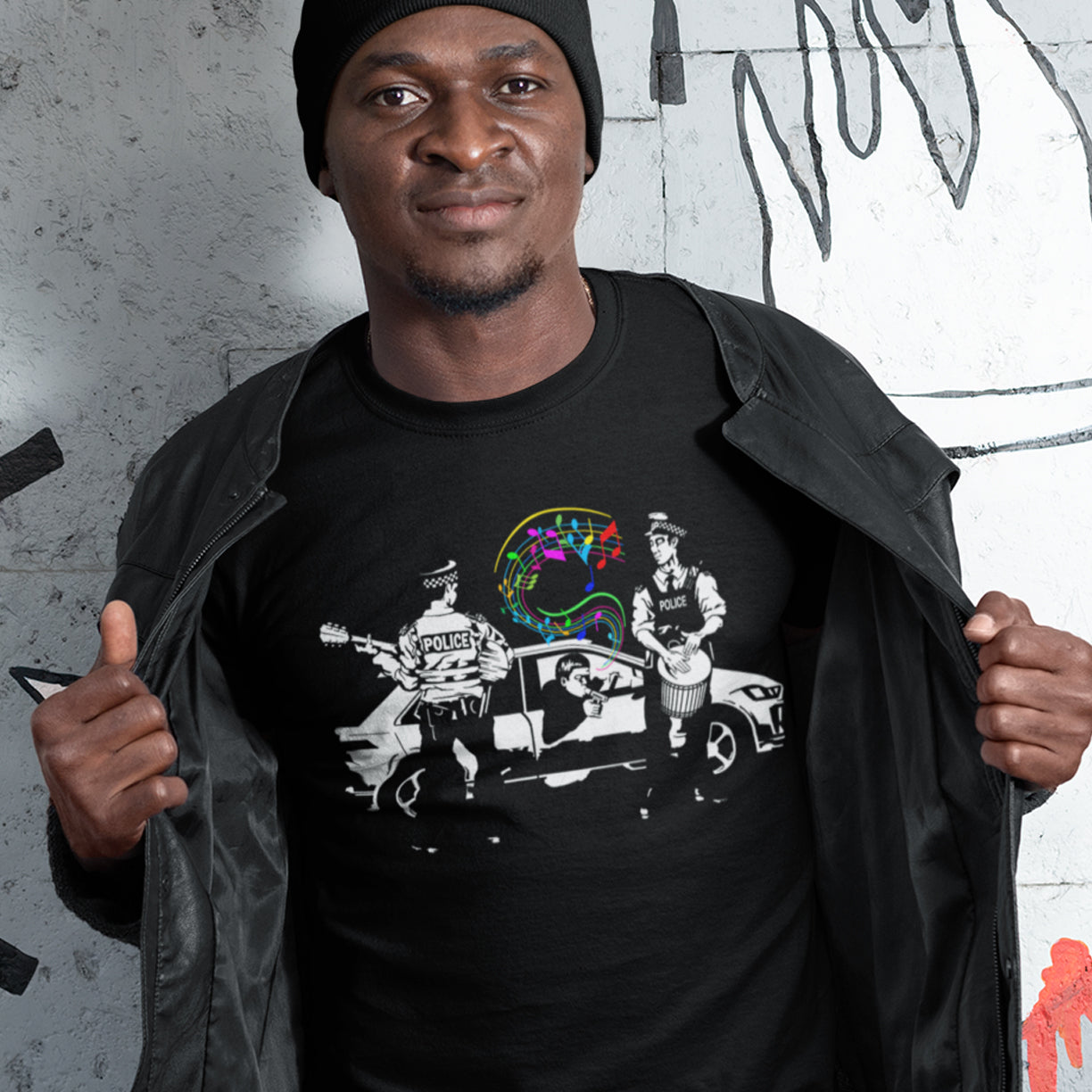 Man showing off musical police t-shirt. A witty Banksy style stencil design depicting an alternative reality. We can only dream of the day the police pull you over to try out a new tune on the breathalyser. Underground art for people who think outside the box. Made from 100% organic ring-spun cotton, this humorous stencil art t-shirt is unisex, high-quality, super comfy, and best of all, eco-friendly.