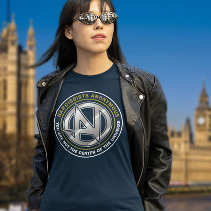 Person wearing a t-shirt with 'Narcissists Anonymous' text in front of a blurred background. A satirical counter culture t shirt design suggesting narcissism is an illness in need of treatment. Wouldn't it be good if there was a place narcissists could go to get therapy and support for their disease. Made from 100% organic ring-spun cotton, this emotional intelligence t-shirt is unisex, high-quality, super comfy, and best of all, eco-friendly.