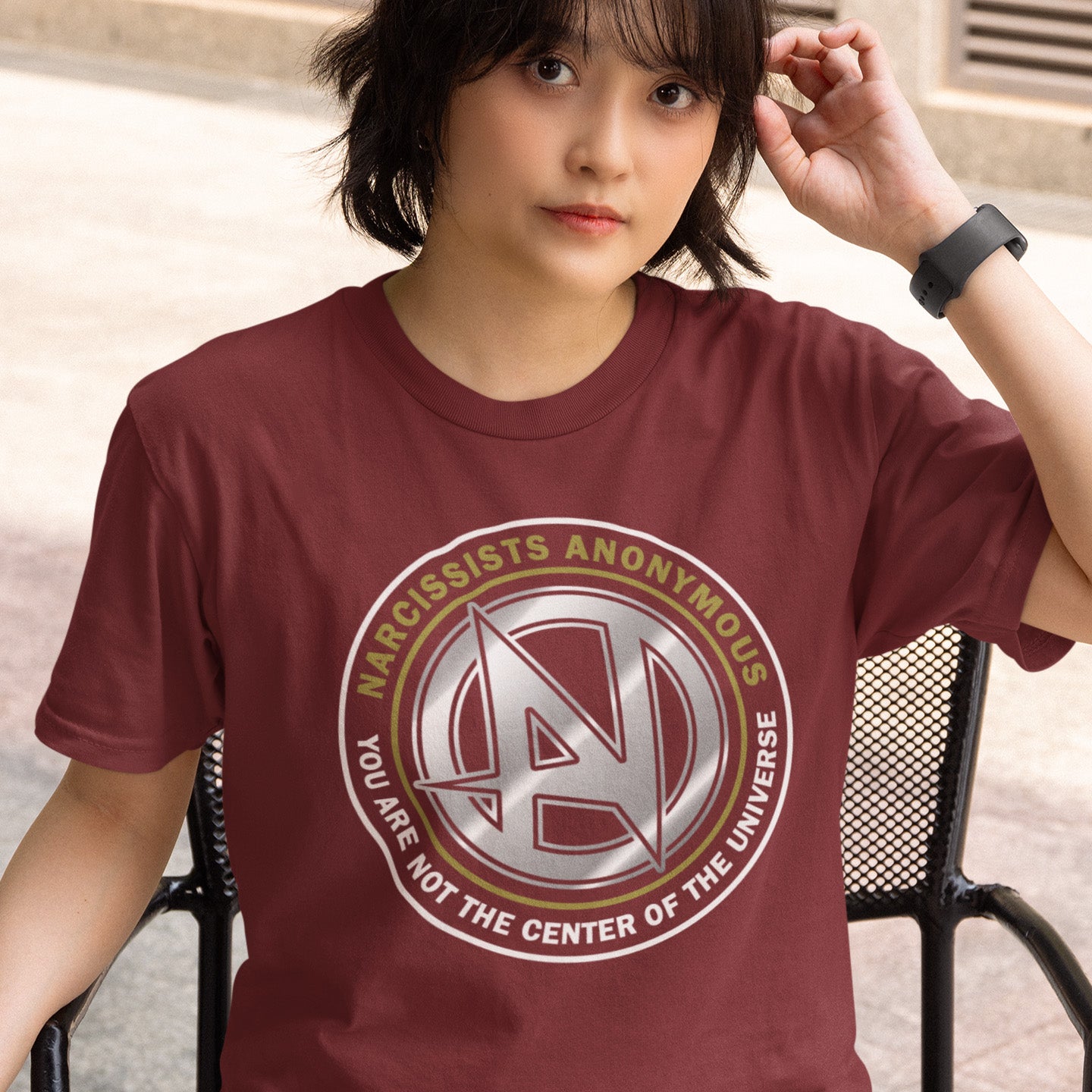 Person wearing a burgundy t-shirt with narcissists anonymous logo and text. A satirical counter culture t shirt design suggesting narcissism is an illness in need of treatment. Wouldn't it be good if there was a place narcissists could go to get therapy and support for their disease. Made from 100% organic ring-spun cotton, this emotional intelligence t-shirt is unisex, high-quality, super comfy, and best of all, eco-friendly.