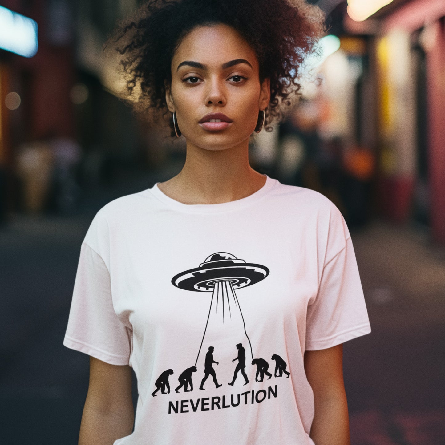 Person wearing a white t-shirt with a UFO and evolution graphic, text 'NEVERLUTION' on a city street. An alien conspiracy theory t-shirt suggesting a different path of our evolution. Did evolution never really happen the way we are told, or is there a more intergalactic and colourful answer ? Made from 100% organic ring-spun cotton, this conspiracy theory t-shirt is unisex, high-quality, super comfy, and best of all, eco-friendly.