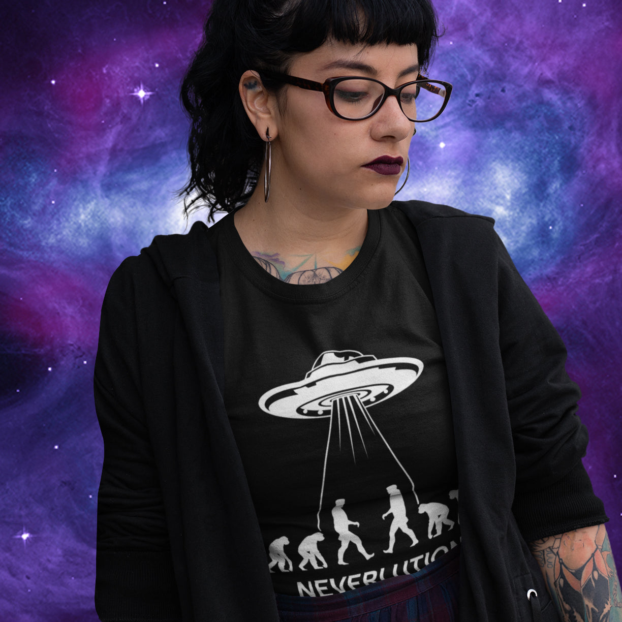 Person wearing a black t-shirt with a UFO design against a cosmic background. An alien conspiracy theory t-shirt suggesting a different path of our evolution. Did evolution never really happen the way we are told, or is there a more intergalactic and colourful answer ? Made from 100% organic ring-spun cotton, this conspiracy theory t-shirt is unisex, high-quality, super comfy, and best of all, eco-friendly.