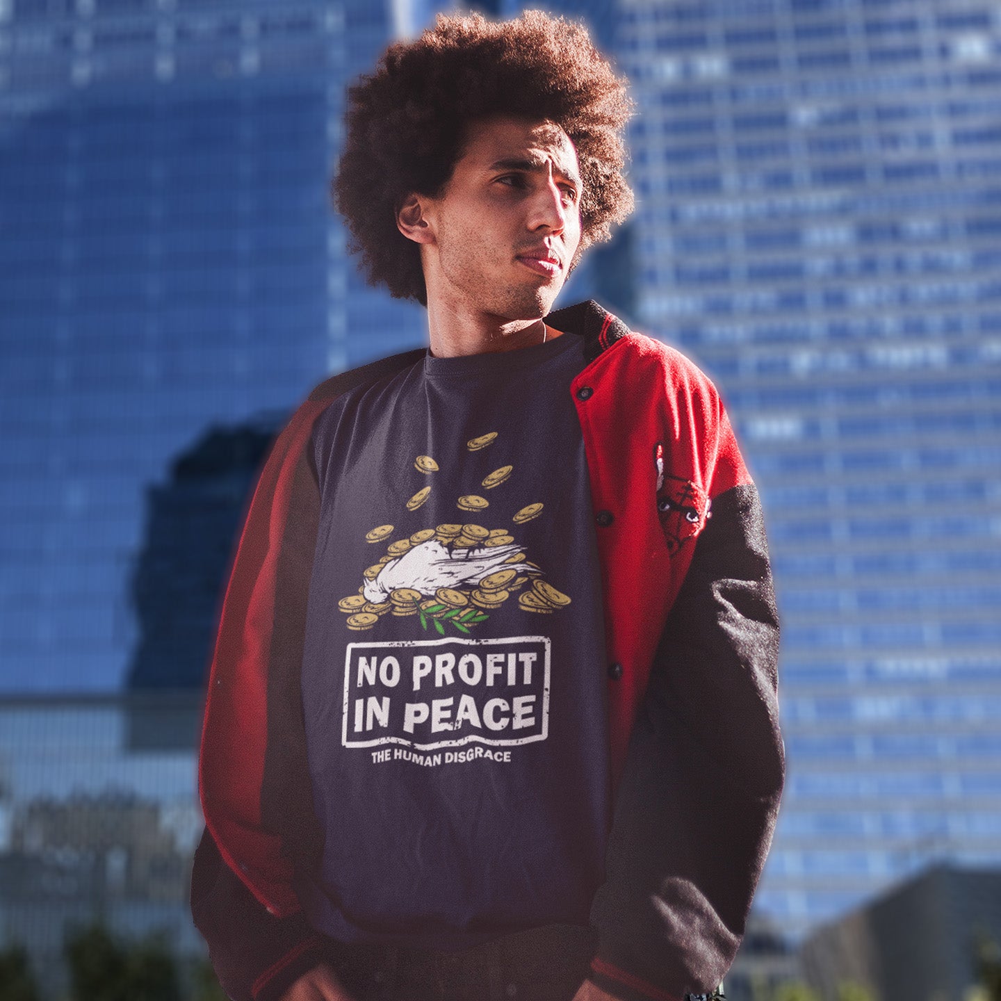 Person wearing a t-shirt with 'No Profit in Peace' text and graphic, standing in front of a blue building. An anti-war t-shirt exposing the true reason for war. A cynical view of why peace has never really been an option and what big business war has always been. Made from 100% organic ring-spun cotton, this political t-shirt is unisex, high-quality, super comfy, and best of all, eco-friendly.