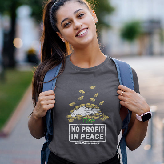 A woman wearing a dark gray graphic t-shirt with a 'No Profit in Peace' cartoon illustration, carrying a blue backpack on a blurred outdoor path.
