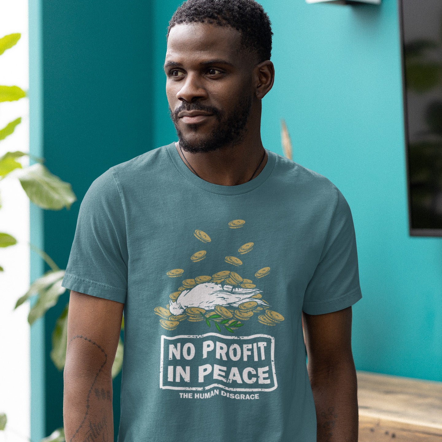 Man wearing a stargazer t-shirt with 'No Profit in Peace' graphic design. An anti-war t-shirt exposing the true reason for war. A cynical view of why peace has never really been an option and what big business war has always been. Made from 100% organic ring-spun cotton, this political t-shirt is unisex, high-quality, super comfy, and best of all, eco-friendly.