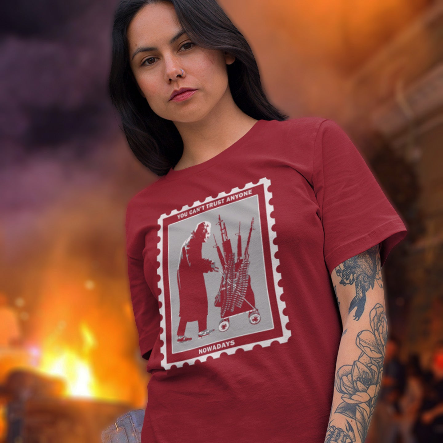Woman wearing a burgundy t-shirt with a graphic design, standing against a blurred background. A Banksy style street art stencil t-shirt displaying a humorous view of how careful you have to be living in a culture of fear when you come from a more trusting generation. Made from 100% organic ring-spun cotton, this street art t-shirt is unisex, high-quality, super comfy, and best of all, eco-friendly.