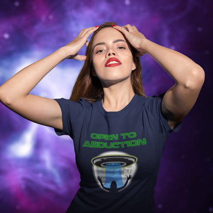 Woman wearing a t-shirt with 'Open to Abduction' design against a cosmic background. A funny alien abduction t-shirt design for those who feel a distance forming between them and the rest of the human race. Made from 100% organic ring-spun cotton, this alien abduction t-shirt is unisex, high-quality, super comfy, and best of all, eco-friendly.