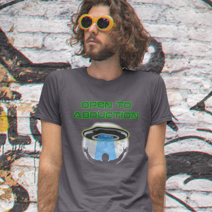 Person wearing a t-shirt with 'Open to Abduction' graphic design in front of a graffiti-covered wall. A funny alien abduction t-shirt design for those who feel a distance forming between them and the rest of the human race, and are not too impressed with our lack of effort to save the planet. This design depicts a man open to abduction. Made from 100% organic ring-spun cotton, this witty alien abduction t-shirt is unisex, high-quality, super comfy, and best of all, eco-friendly.