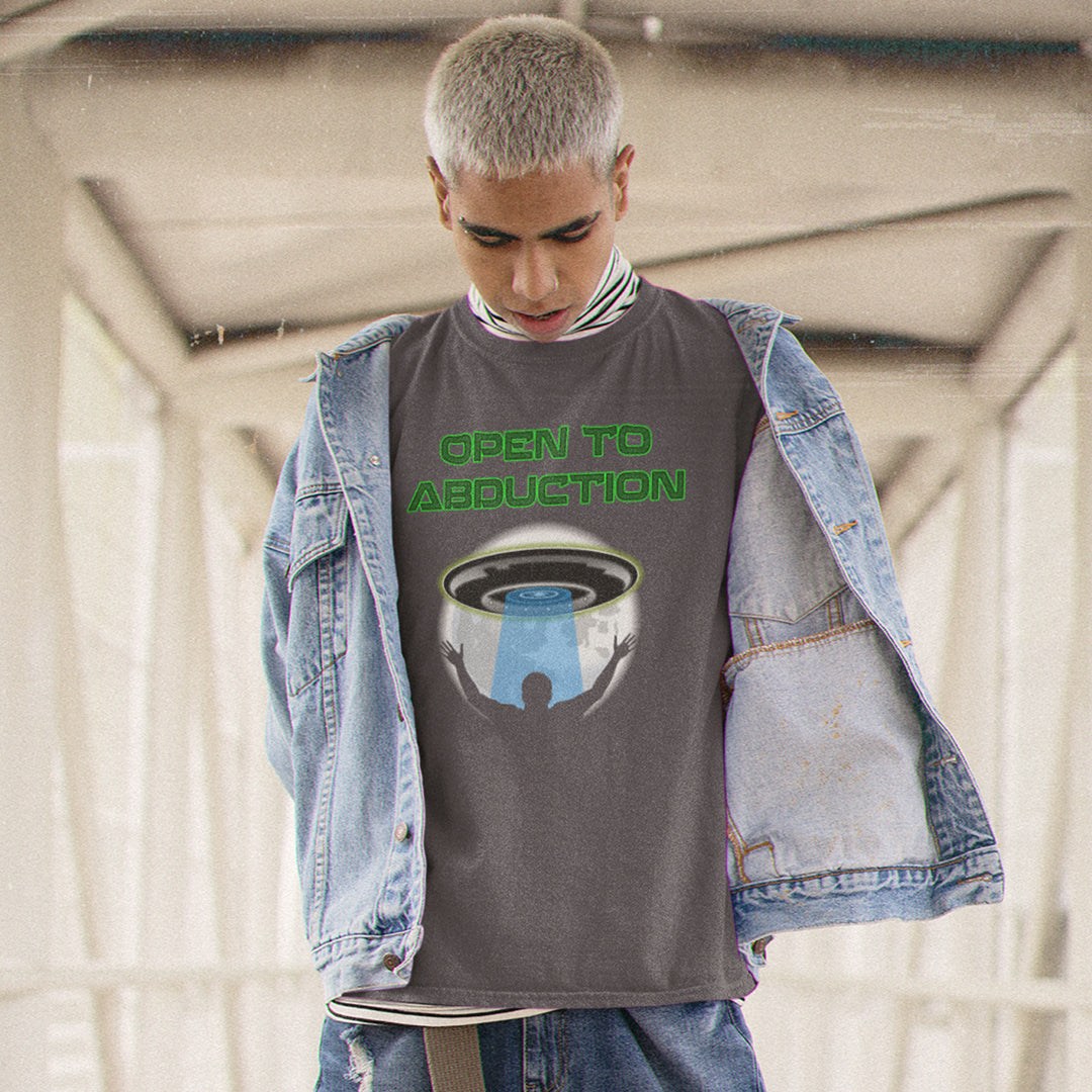 Man standing outside wearing an anthracite coloured "OPEN TO ABDUCTION" t shirt.