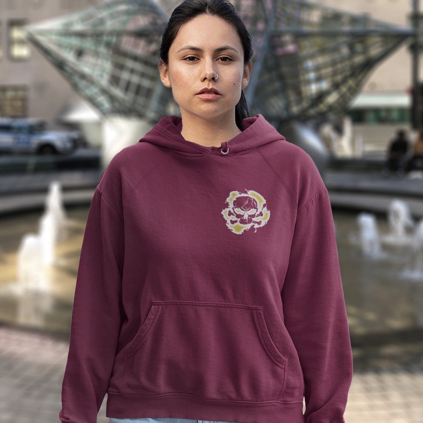 Person wearing a burgundy hoodie with a logo in an outdoor setting. A save the Earth hoodie in a grey design, for nature lovers who have environmental concern. Planet welfare should be something we can all agree on. Comfortable and practical. It's extra soft and has a convenient front pouch pocket. Made from organic cotton and recycled polyester, this save the world hoodie is a great eco-friendly choice.