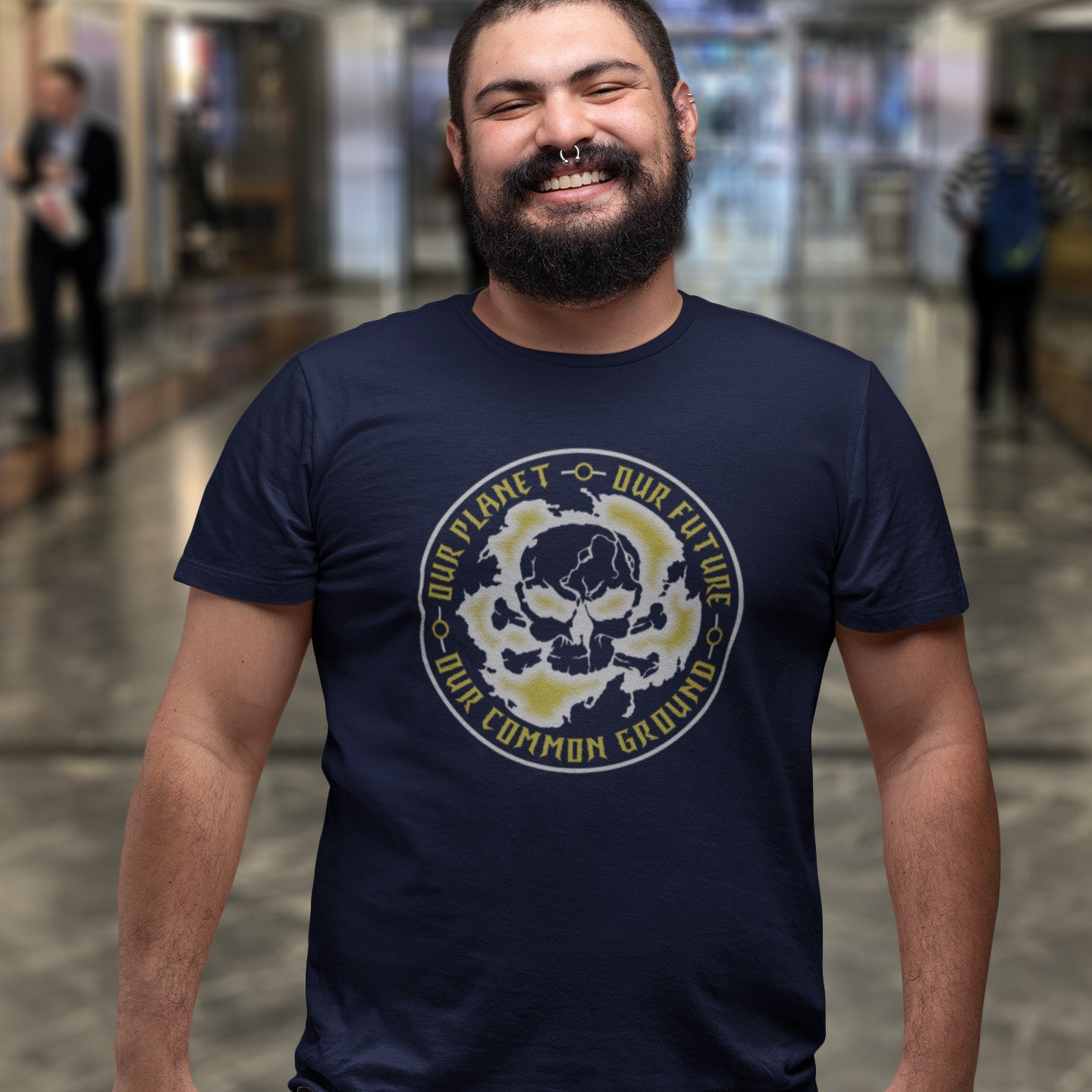 Man wearing a French navy blue t-shirt with a graphic design in an indoor setting. A save the planet t shirt for nature lovers who have environmental concern. Planet welfare should be something we can all agree on. Made from 100% organic ring-spun cotton, this save the Earth t shirt is unisex, high-quality, super comfy, and best of all, eco-friendly. Grey design.