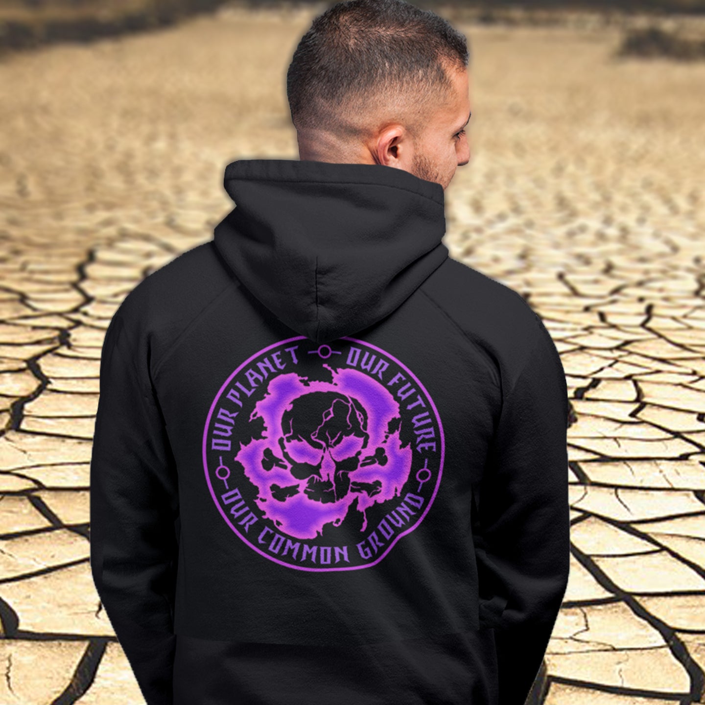 Person wearing a black hoodie with a purple graphic design on the back, standing in a dry, cracked landscape. An environmental concern hoodie in a pink design, for nature lovers who want to save the planet. Planet welfare should be something we can all agree on. Comfortable and practical. It's extra soft and has a convenient front pouch pocket. Made from organic cotton and recycled polyester, this environmental awareness hoodie is a great eco-friendly choice.
