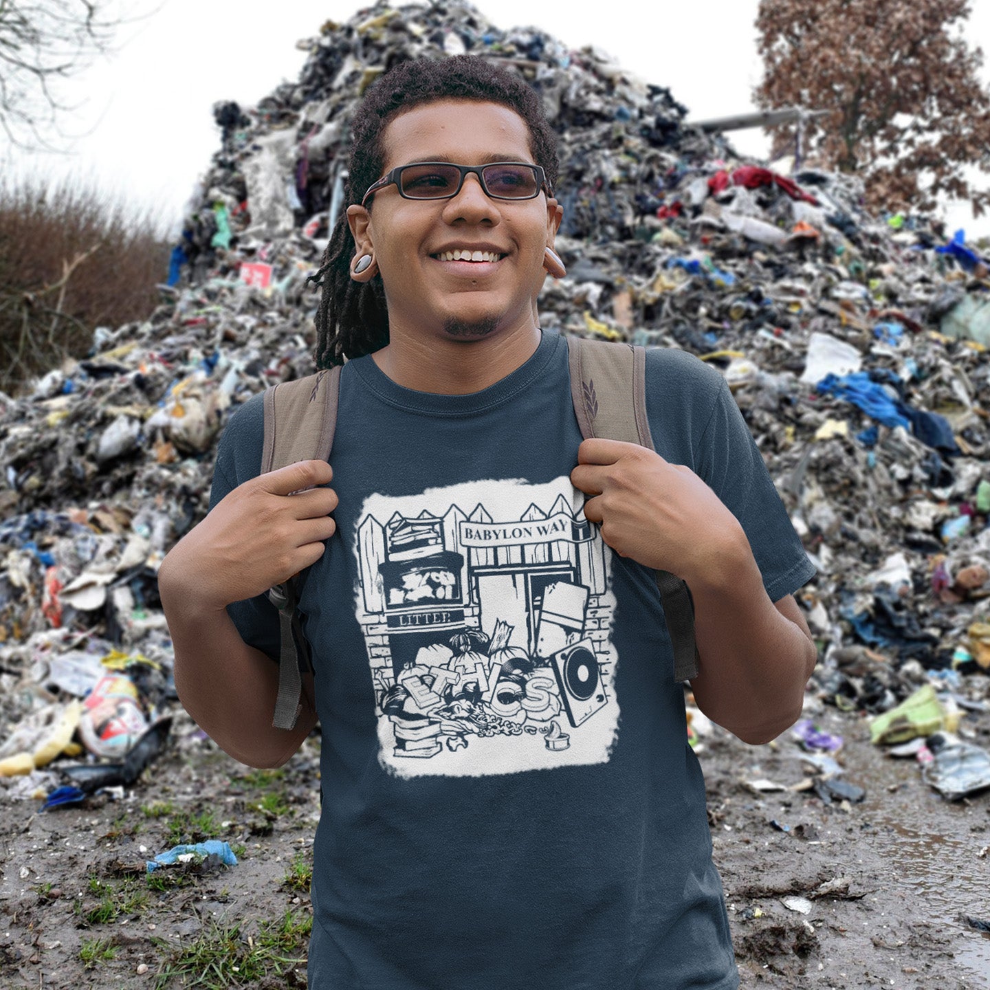 Person wearing a t-shirt with a graphic design standing in front of a large pile of trash. A stencil graffiti t shirt depicting the end of integrity. There doesn't seem to be a place for ethics anymore in this mercenary world of money worship. It's amazing what people throw out these days. This unique street Art design depicts a sign of the times. Made from 100% organic ring-spun cotton, this social awareness t shirt is unisex, high-quality, super comfy, and best of all, eco-friendly.