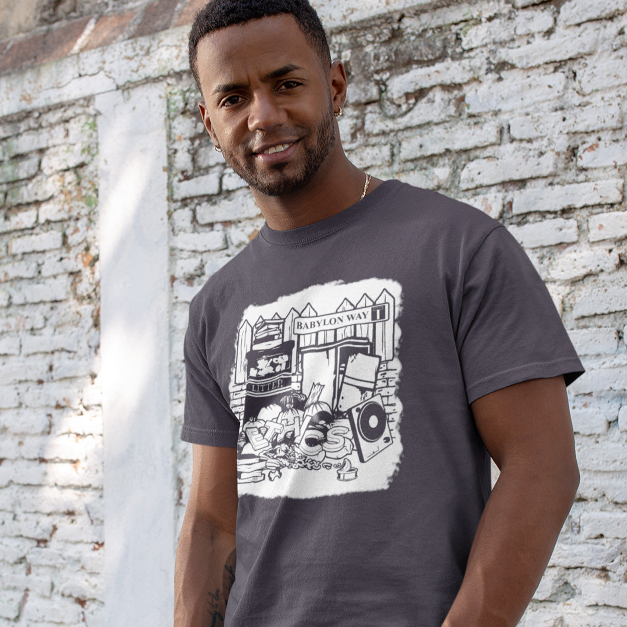 Man wearing an anthracite t-shirt with a graphic design standing against a brick wall. A stencil graffiti t shirt depicting the end of integrity. There doesn't seem to be a place for ethics anymore in this mercenary world of money worship. It's amazing what people throw out these days. This unique street Art design depicts a sign of the times. Made from 100% organic ring-spun cotton, this social awareness t shirt is unisex, high-quality, super comfy, and best of all, eco-friendly.