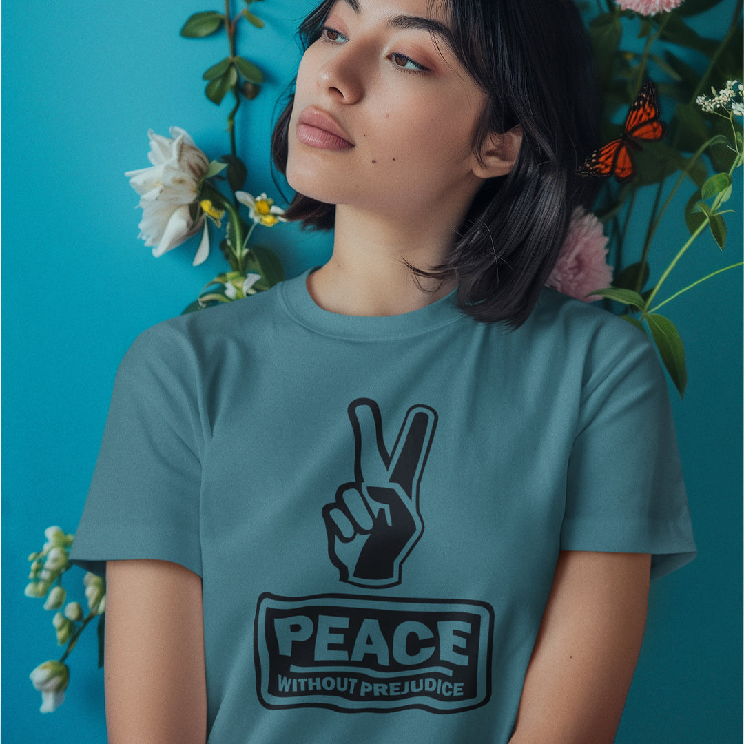 A woman gazing sideways, wearing a stargazer blue t-shirt with a black printed peace sign and "Peace without prejudice" written underneath.