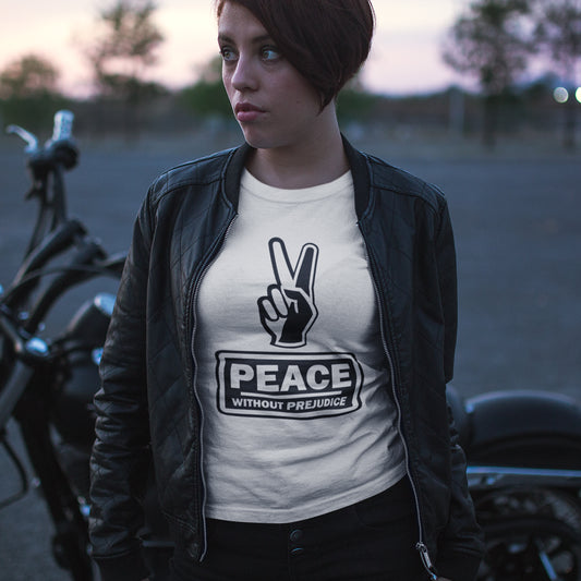 Person wearing a t-shirt with 'Peace Without Prejudice' design, standing next to a motorcycle. This anti racism t-shirt highlights how equality is a key component of peace on Earth. For us to live in harmony we need to improve our emotional intelligence and acceptance of differences, especially when it comes to racial issues. Made from 100% organic ring-spun cotton, this anti racist t shirt is unisex, high-quality, super comfy, and best of all, eco-friendly.