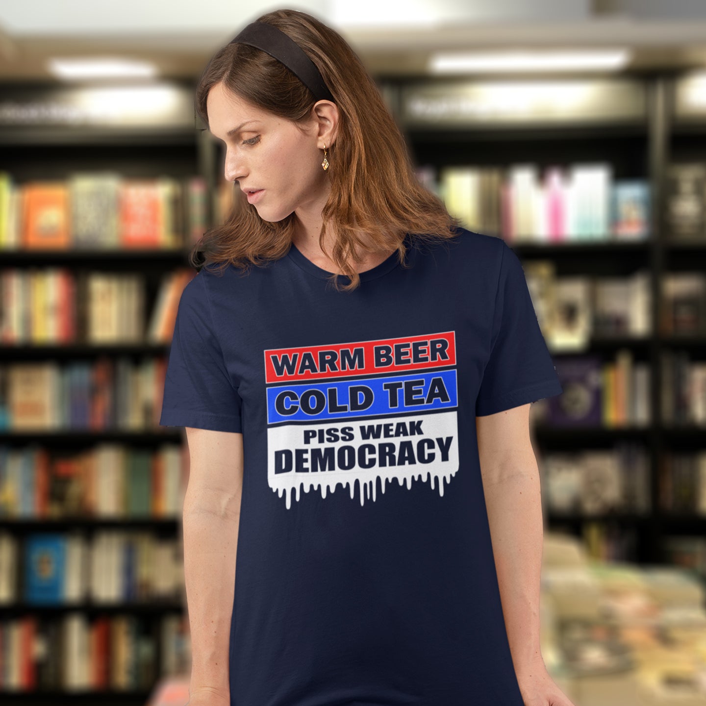 Woman wearing a t-shirt with a political message in a bookstore. This anti-establishment t-shirt comes with a short poem. Warm beer, cold tea, piss weak democracy. These are the things no one wants served to them !! this unique political t-shirt design is idea for any demonstration or protest rally. Made from 100% organic ring-spun cotton, this political anti government t-shirt is unisex, high-quality, super comfy, and best of all, eco-friendly.