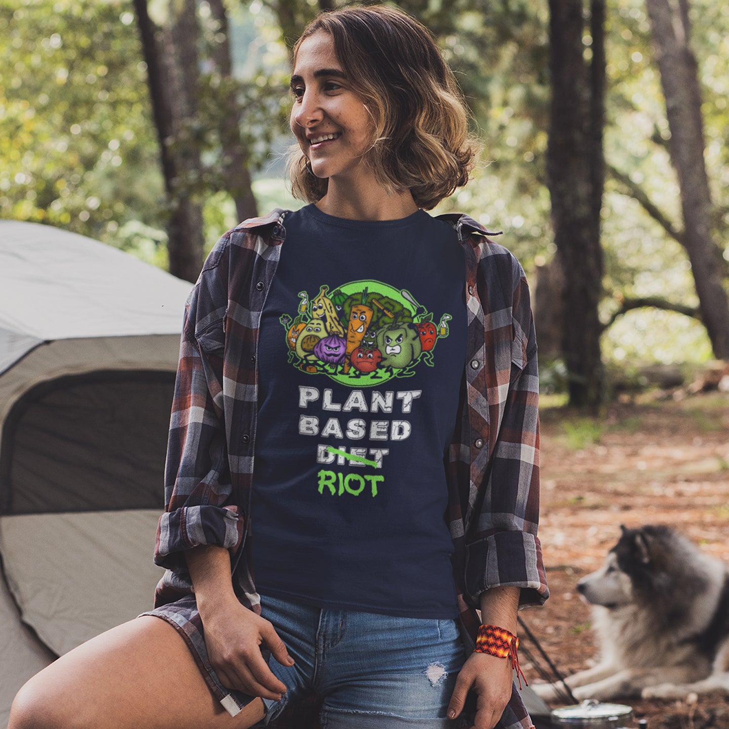 Woman wearing a 'Plant Based Diet Riot' t-shirt in a forest setting with a dog. A funny plant based vegan t-shirt design to highlight the speed at which people seem to be embracing a plant based diet. Welcome to the revolution ! Made from 100% organic ring-spun cotton, this humorous vegan t-shirt is unisex, high-quality, super comfy, and best of all, eco-friendly.