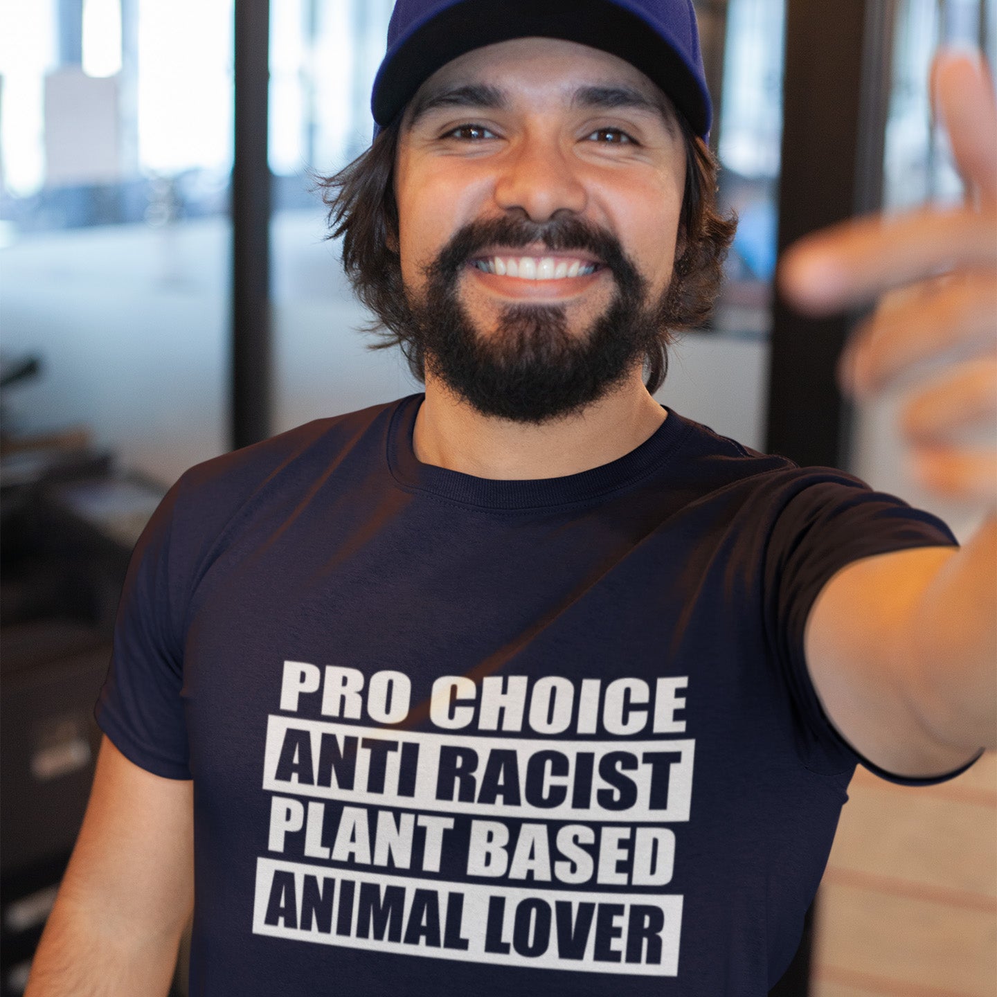 Man wearing a French navy t-shirt with pro-choice, anti-racist, plant-based, and animal lover text. A plant based t-shirt design intertwined with Pro Choice, Anti Racism, and Animal loving, characteristics that often go together. Made from 100% organic ring-spun cotton, this vegan t-shirt is unisex, high-quality, super comfy, and best of all, eco-friendly.