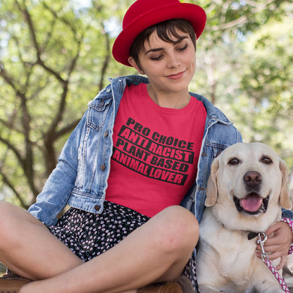 Person wearing a red shirt with text, sitting outdoors with a dog. A plant based t-shirt design intertwined with Pro Choice, Anti Racism, and Animal loving, characteristics that often go together. Made from 100% organic ring-spun cotton, this vegan t-shirt is unisex, high-quality, super comfy, and best of all, eco-friendly.