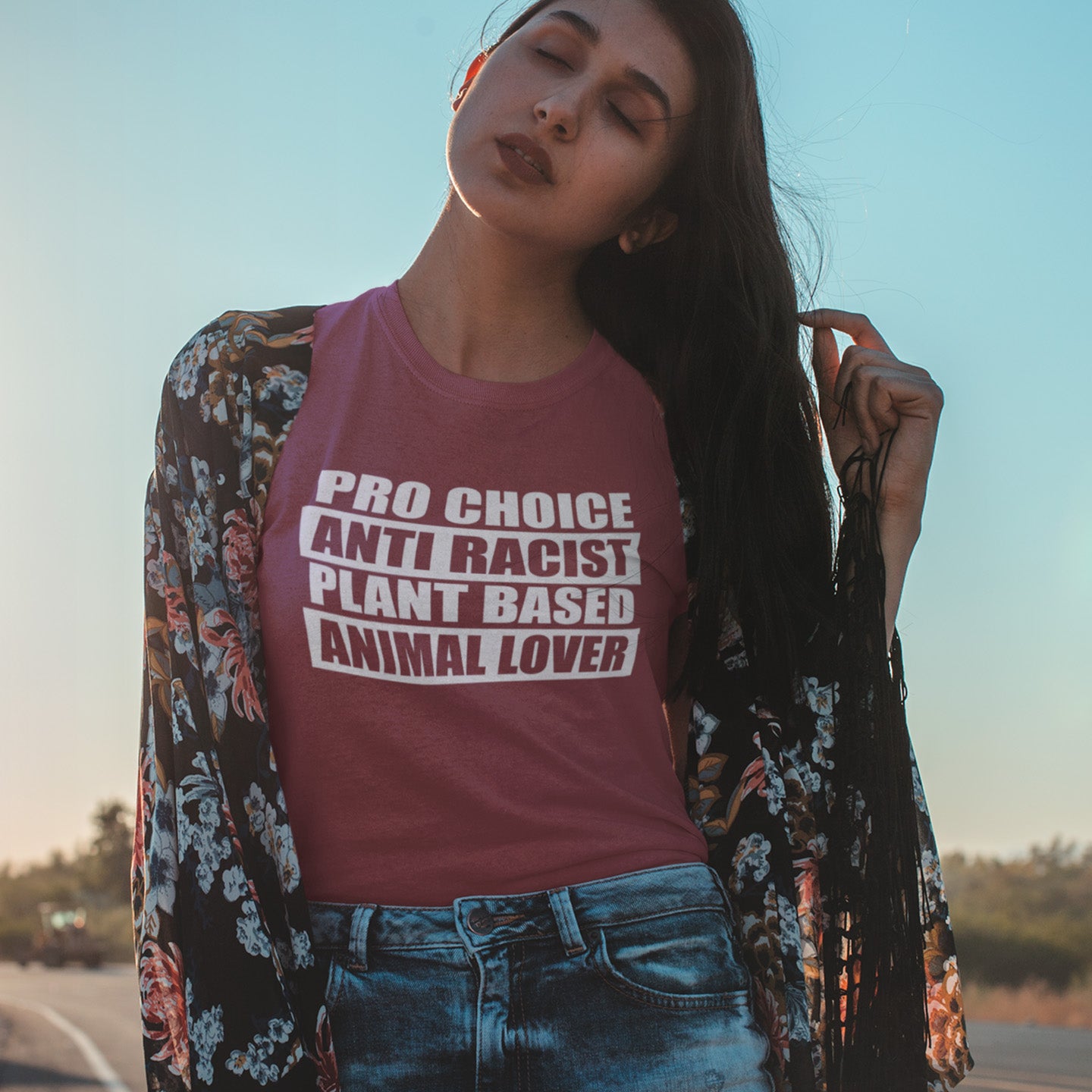 Woman wearing a t-shirt with pro-choice, anti-racist, plant-based, animal lover text outdoors. A plant based meat free t shirt design intertwined with Pro Choice, Anti Racism, and Animal loving, characteristics that often go together. Made from 100% organic ring-spun cotton, this dairy free t shirt is unisex, high-quality, super comfy, and best of all, eco-friendly.