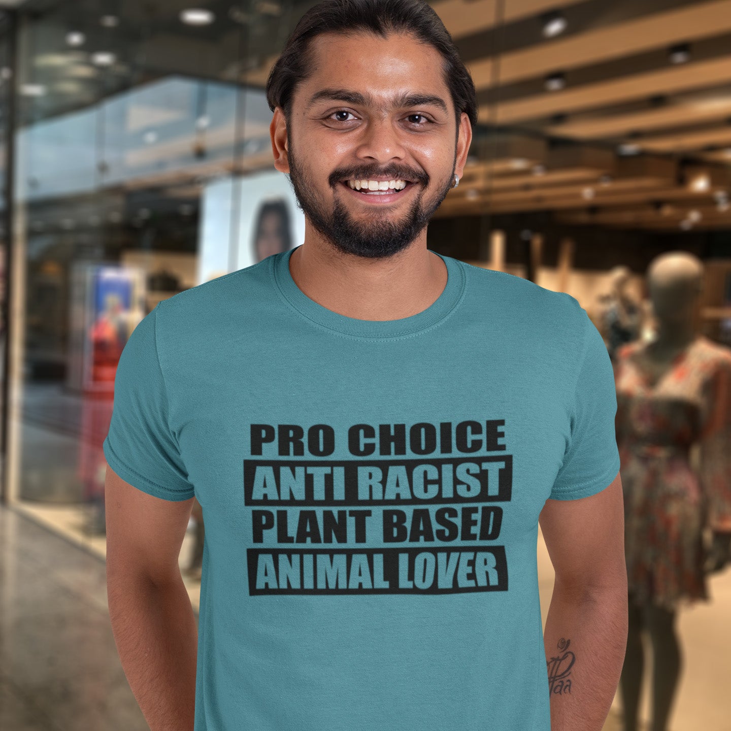 Man wearing a stargazer t-shirt with text in a modern indoor setting. A plant based meat free t shirt design intertwined with Pro Choice, Anti Racism, and Animal loving, characteristics that often go together. Made from 100% organic ring-spun cotton, this dairy free t shirt is unisex, high-quality, super comfy, and best of all, eco-friendly.