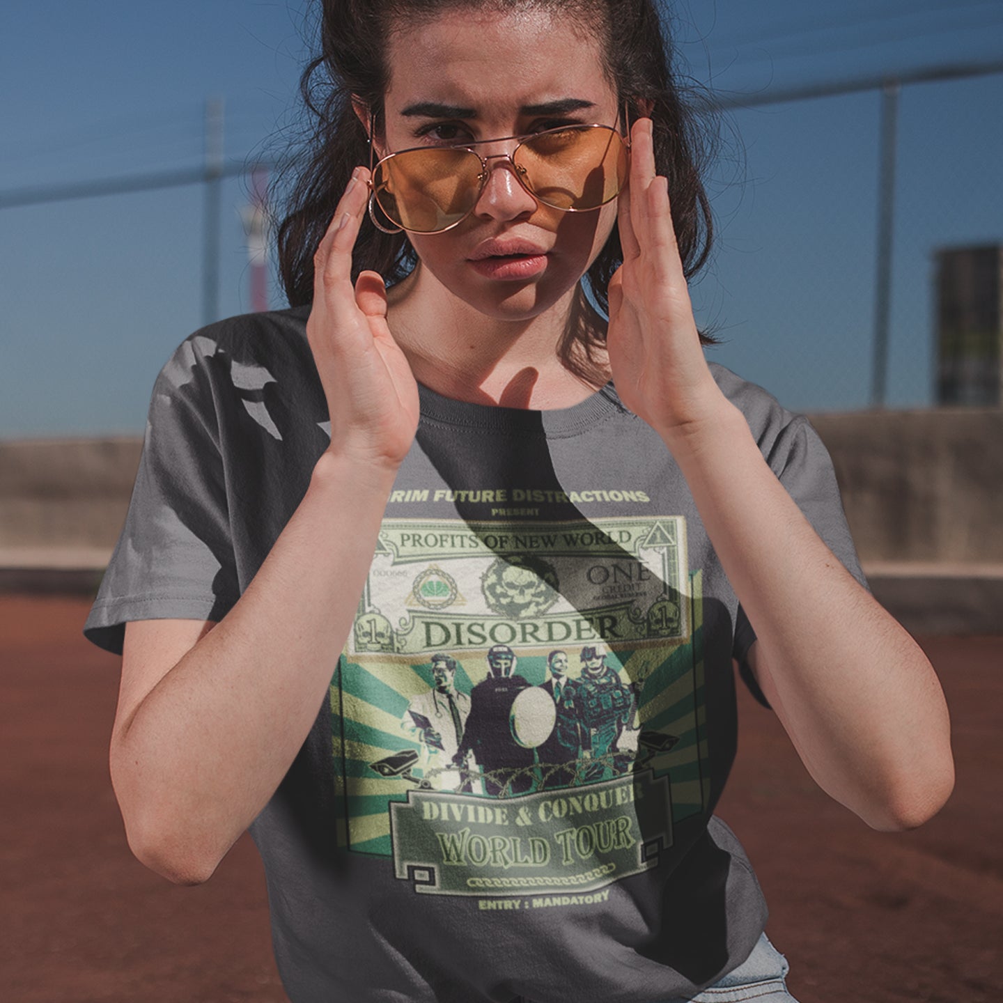 Person wearing a t-shirt with a graphic design, standing outdoors. A non conformist t shirt in the style of a band tour poster. This satirical t-shirt design highlights the forces that influence our society now, and for the foreseeable future. A spoof band t-shirt to create social awareness. Made from 100% organic ring-spun cotton, this anti government t shirt is unisex, high-quality, super comfy, and best of all, eco-friendly.