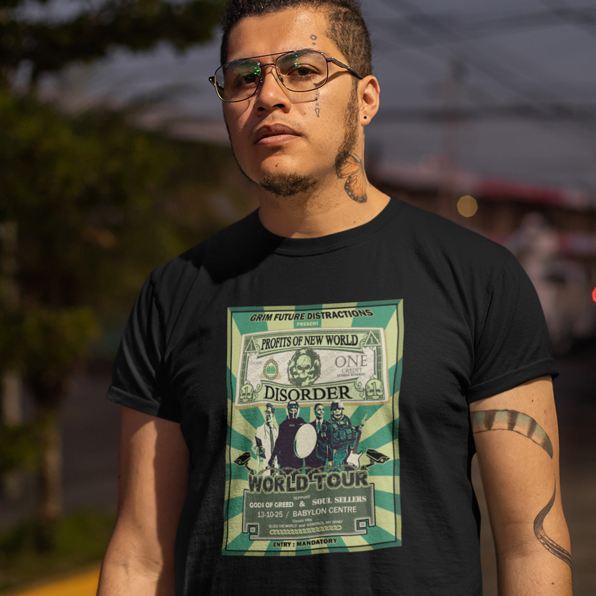 Man wearing a black t-shirt with a graphic design of a world tour poster. A political t-shirt is in the style of a band tour poster. A non conformist t shirt in the style of a band tour poster. This satirical t-shirt design highlights the forces that influence our society now, and for the foreseeable future. A spoof band t-shirt to create social awareness. Made from 100% organic ring-spun cotton, this anti government t shirt is unisex, high-quality, super comfy, and best of all, eco-friendly.