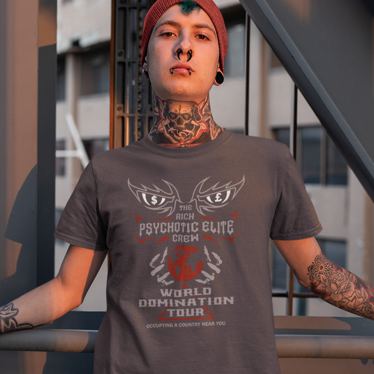 Person wearing an anthracite t-shirt with graphic design and text, standing outdoors. This conspiracy theory t shirt design combines a belief in an elite rich cabal with a rock band tour poster style. Show your disgust in greed and power hunger with this very satirical tour design. If the rich elite started a band this is what it would look like. Made from 100% organic ring-spun cotton, this conspiracy theorist t shirt is unisex, high-quality, super comfy, and best of all, eco-friendly.